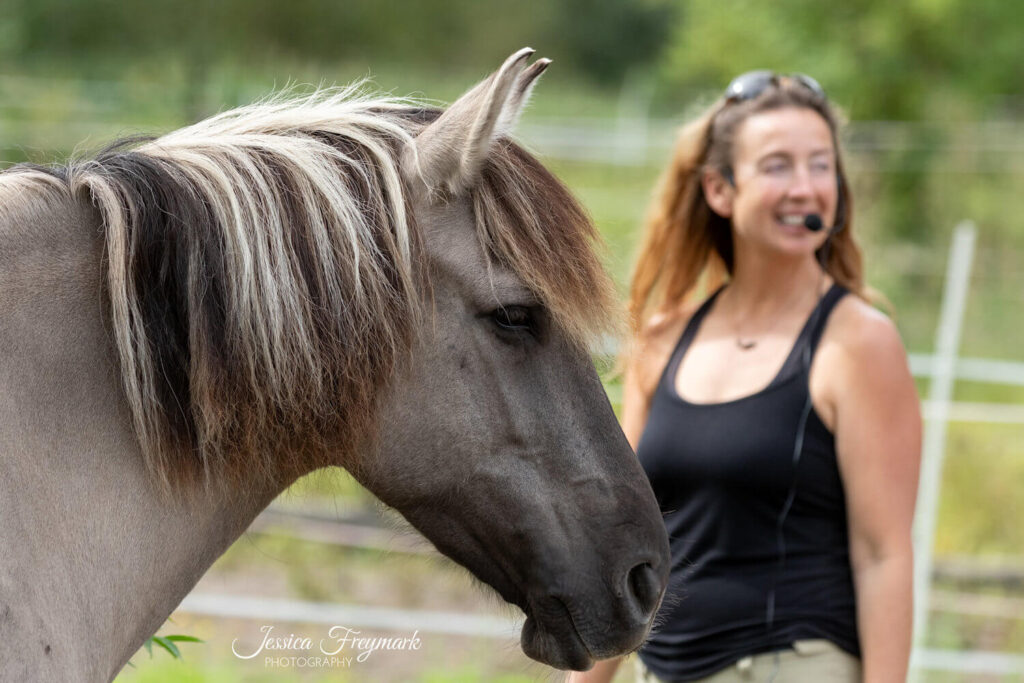Ein Pferd steht vor Elsa Sinclair und beide schauen in die gleiche Richtung