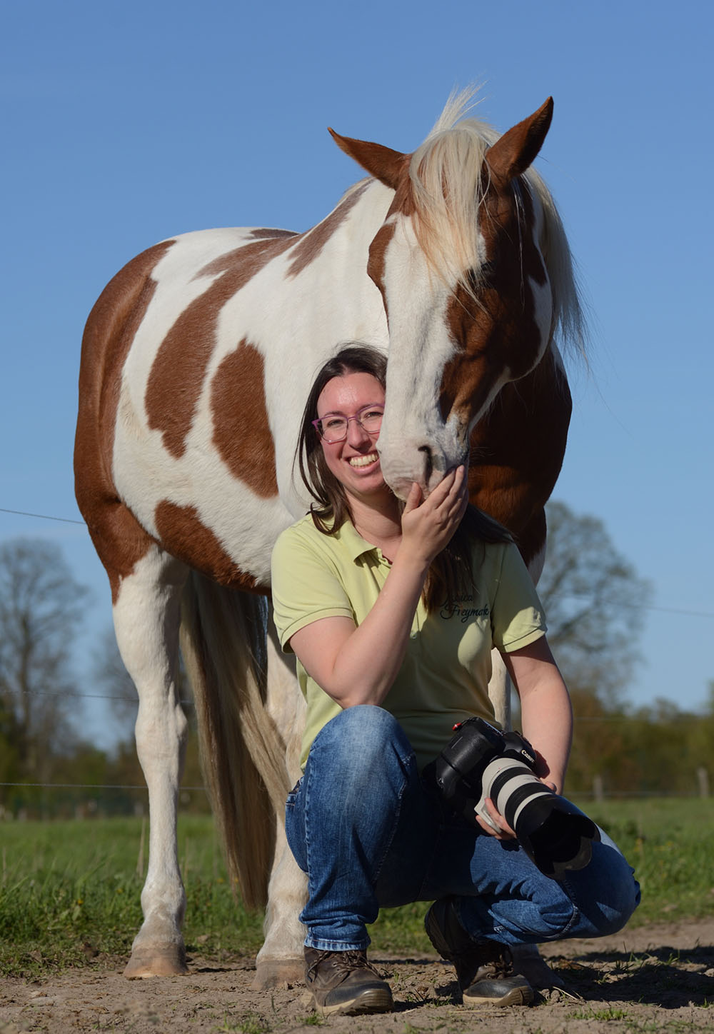 Jessica Freymark und ihr Pflegepferd Jack, ein Fuchsschecke, kuscheln während sie eine Kamera in der Hand hält